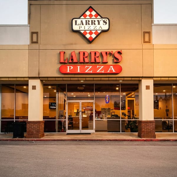 Exterior of Larry's Pizza restaurant with large windows, red signage, and a checkered logo.